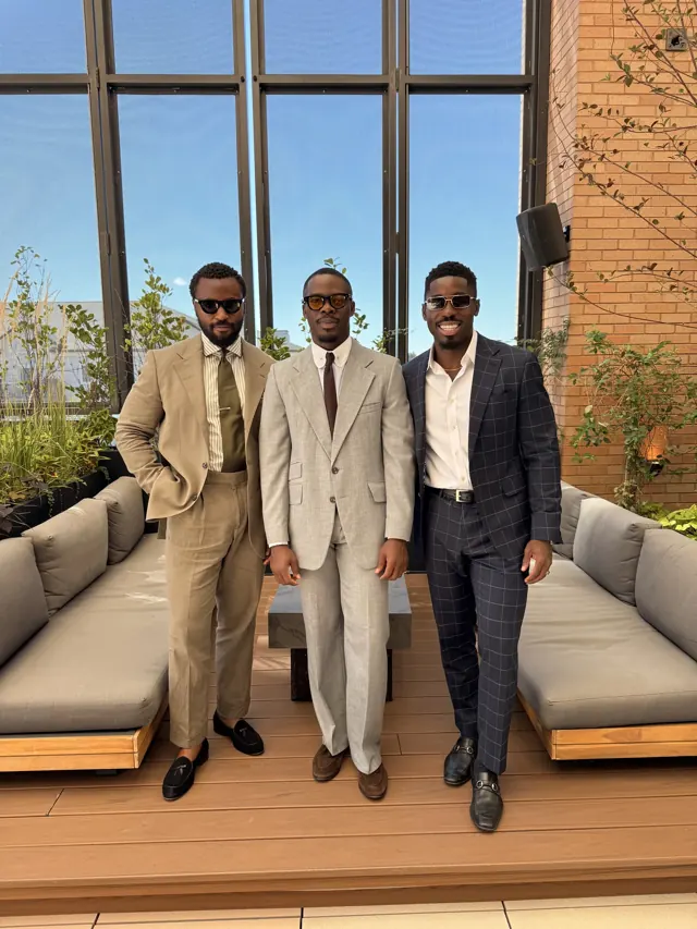Clients in custom tailoring in tan, beige and navy check on a rooftop terrace