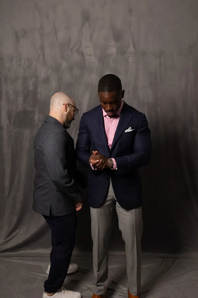 Kobe Apponsah fitting a client in a navy custom suit jacket